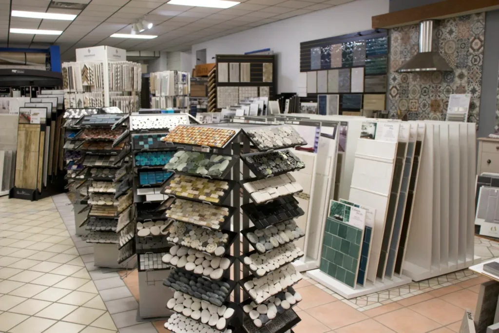 Flooring showroom with tiered racks displaying mosaic, stone, and wall tile samples.