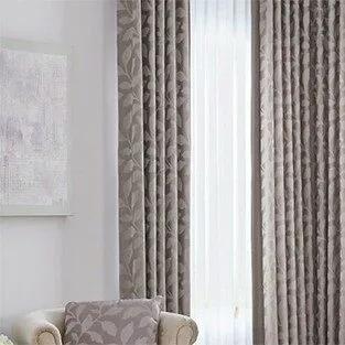 Floor-length patterned drapes framing sheer window curtains.