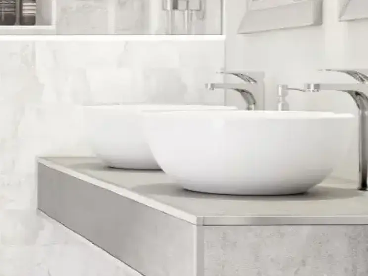 Double white vessel sinks with chrome faucets on a modern bathroom vanity.