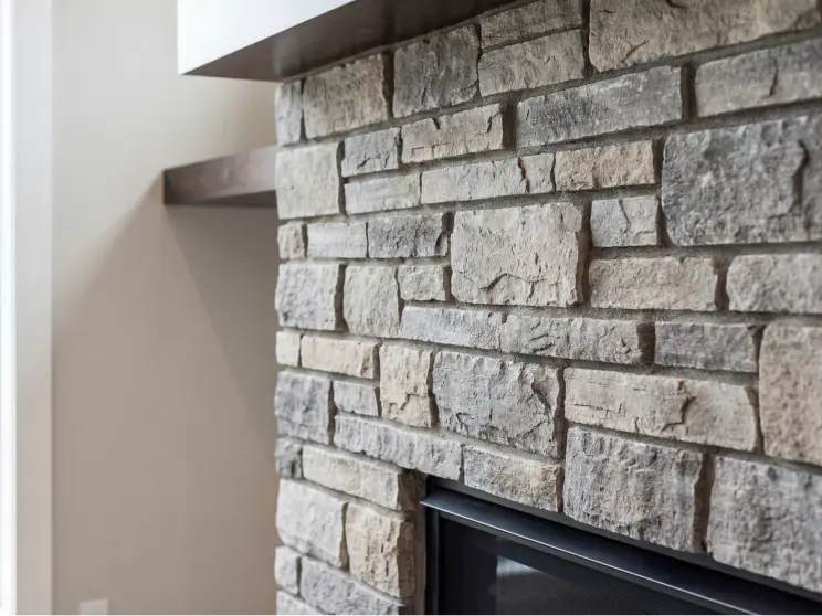Stacked stone fireplace surround with a dark mantel.
