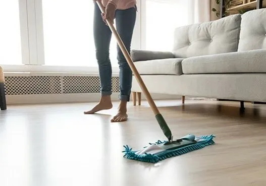 Person mopping a laminate floor with a microfiber mop.
