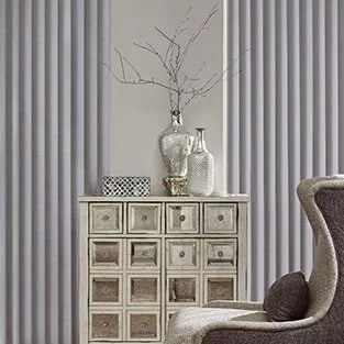 Grey fabric vertical blinds beside a mirrored cabinet.