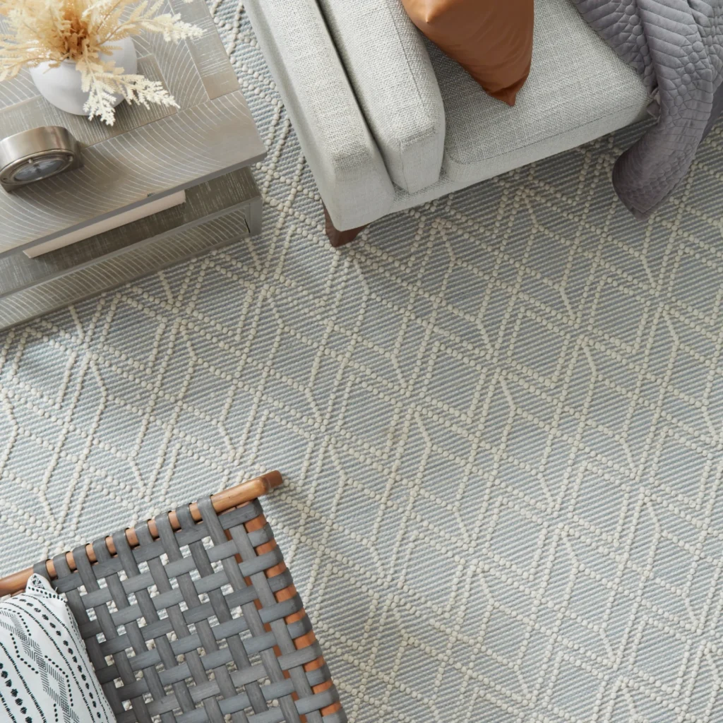 Overhead view of a patterned carpet beneath living room furniture.